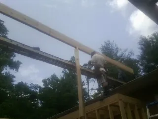 Carpenter setting a ridge beam over a new addition frame — Ice Dam Removal by Roofing Brothers in Ambridge