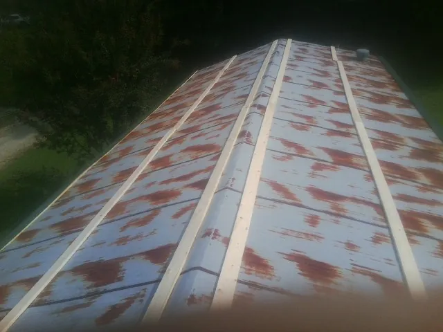 Rusted metal roof panels with new wood purlins before replacement — Storm Damage Roof Repair in Ambridge by Roofing Brothers