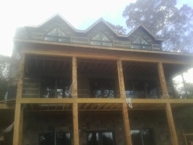Dormers and porch framing on a large log home under construction — Roof Coating work by our crew in Ambridge