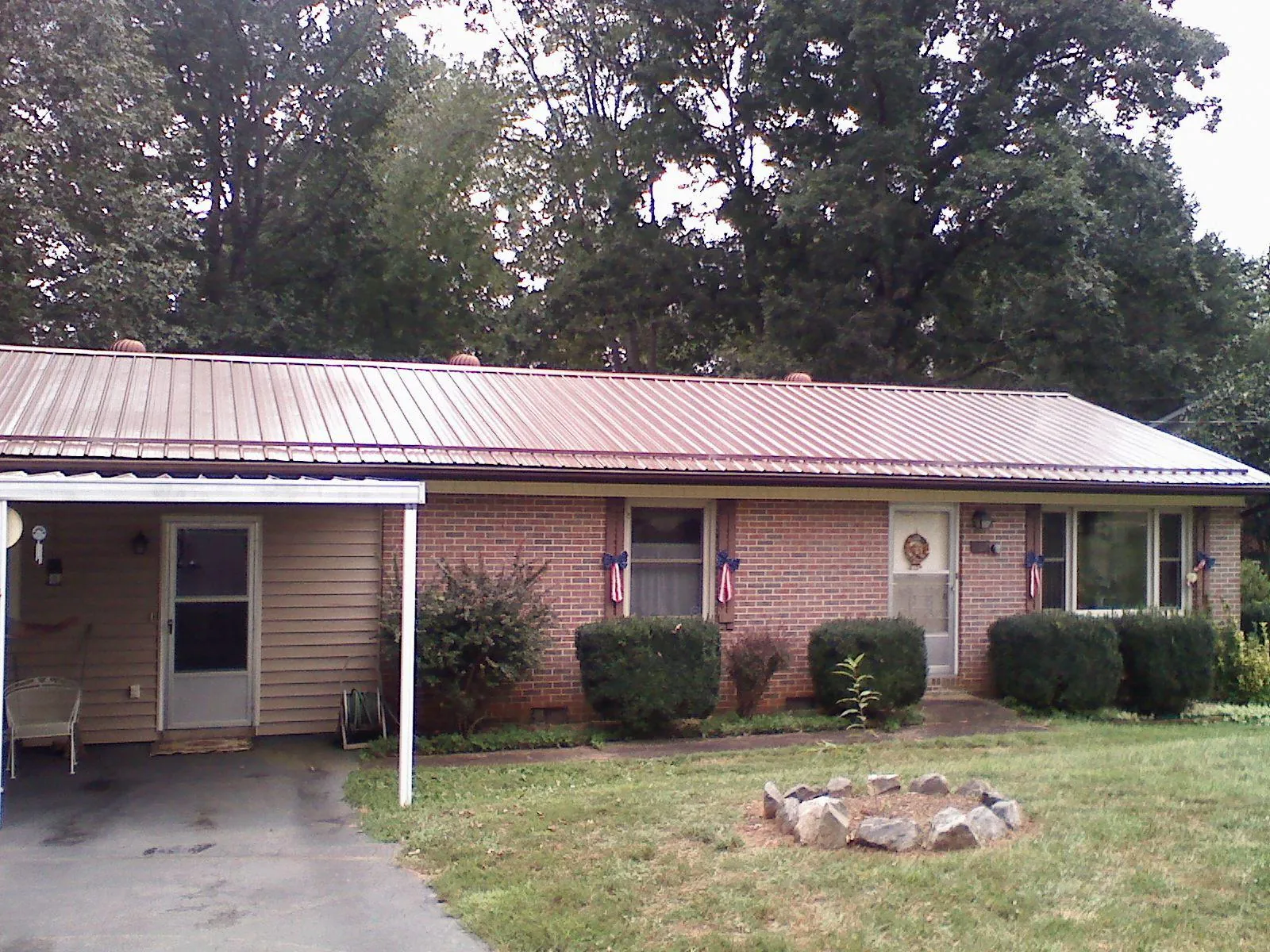 Bronze metal roof and carport on a brick ranch home — Roof Repair work by our crew in Ambridge